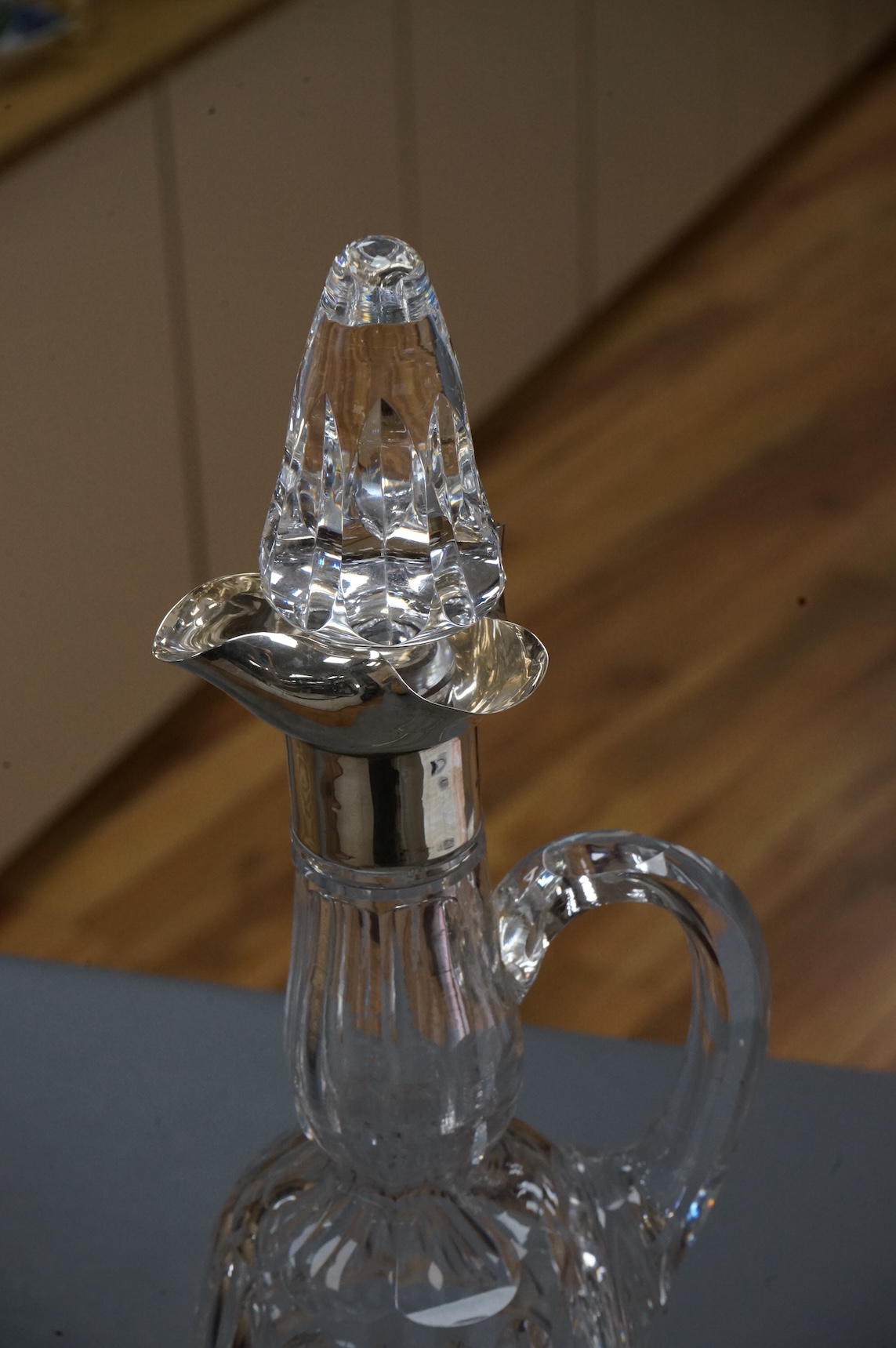 An Edwardian silver mounted cut glass bell shaped single handled decanter, with stopper, by Thomas Webb & Sons Ltd, London, 1902, 34.2cm.
